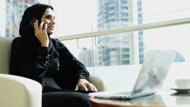 Femme d'affaires travaillant sur un ordinateur portable et parlant sur un téléphone intelligent — Video