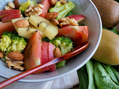 Çeşitli sebze ve meyve salatası, kivi, domates, elma, brokoli, badem, ceviz