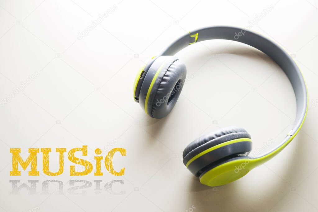 Wireless headphones isolated on white background Green over-ear headset with built-in noise cancellation and microphone. Side view of acoustic stereo systems and the text 