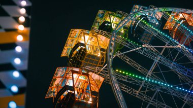 Parlak ışıklı bir dönme dolap kabinine yakın plan ve canlı LED ışıkları olan gece..