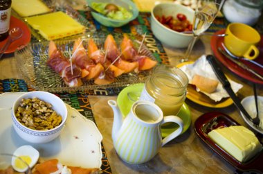 Meyve ve şampanyayla kaplı kahvaltı masası.