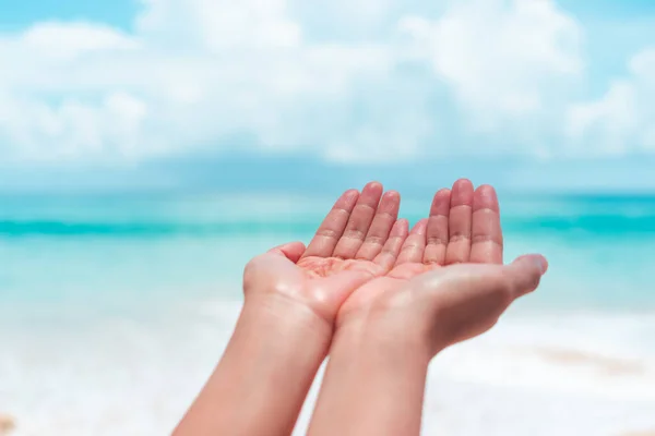Woman hands place together like praying in front of nature clean beach and blue sky  background.
