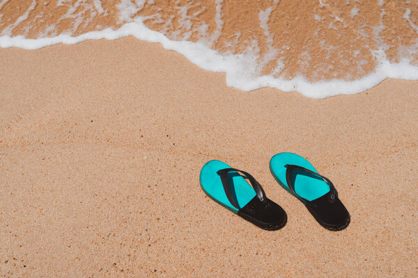 Slippers on the sand at the sea with space , summer holiday and vacation concept.