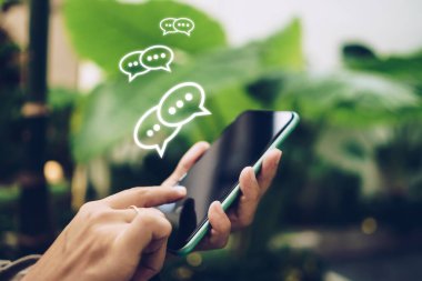 Sohbet ikonlarında akıllı telefon yazma, sohbet etme ya da kısa mesajlar kullanarak el ele tutuşuyorlar. Sosyal medya teknoloji kavramı. Klasik yumuşak renk tonu arkaplanı.
