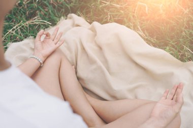 Yoga dersi alan, nefes alan, meditasyon yapan, çimenlikte gezen bir kadın. Şey, sağlık konsepti