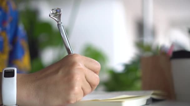 Vrouw Hand Het Schrijven Haar Notebook Met Bokeh Natuur Achtergrond — Stockvideo