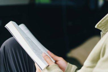 Bir insan arabada kitap okuyor. Rahatlayın ve huzurlu bir ortam oluşturun..