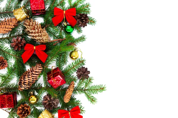 Yeni yıl ve Noel arkaplanı köknar dalları, koniler ve noel eşyaları ile beyaz bir zemin üzerine