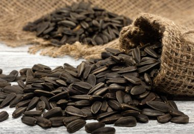 Tohum. Çuval bezinde, tahta bir masanın üzerinde ayçiçeği tohumları yatıyor..