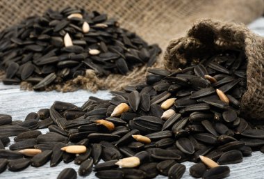 Tohum. Çuval bezinde, tahta bir masanın üzerinde ayçiçeği tohumları yatıyor..