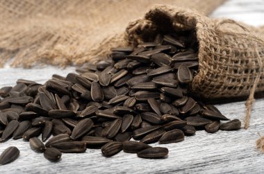 Tohum. Çuval bezinde, tahta bir masanın üzerinde ayçiçeği tohumları yatıyor..