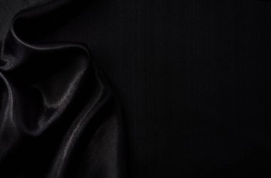 Sanat eserlerinin arka planı ve dekorasyonu için kumaşın koyu kumaş dokusunun bir parçası, güzel buruşmuş ipek ya da keten deseni. Buruşuk bir kumaş parçası.