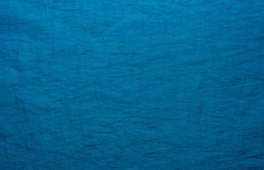Kumaş ya da tuval. Koyu mavi renkte buruşmuş bir kumaş parçası. Elbise dikmek için malzeme