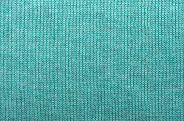 Örgü örüyorum. Turkuaz ya da mavi renkte örülmüş kumaş. Arka plan örgü kumaştan yapılmış. İğne işi