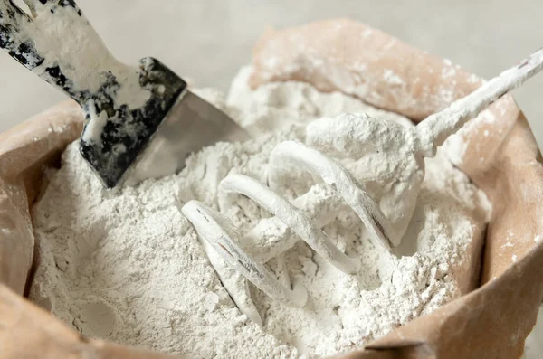 Macun. Bir spatula. El bilgisayarı mikseri. Kullanıma hazır karışımı karıştırmak için macunla karıştırılmış bir çanta. Boyama, boyama ve sıva işi. İnşaat