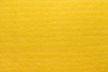 Tekstil. Sarı maddenin arka planı. Genişlemiş süngerimsi lifler. Sünger dokusu. Kapat.