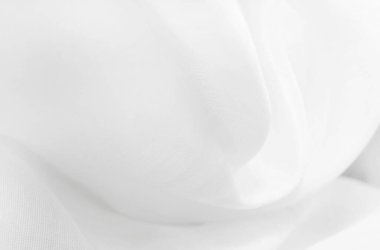 Beyaz kumaş. Kumaşın dokusu, kıvrımları ve dalgaları olan açık renkli bir tonda kumaş veya saten. Kumaş