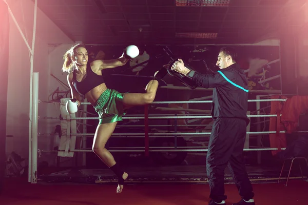 Meisje doet hoge schop in kick boksen — Stockfoto