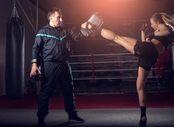 Girl sparkar tillbaka benet under kickboxning praktiken — Stockfoto
