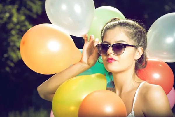 Meisje poseren met ballonnen in de natuur — Stockfoto