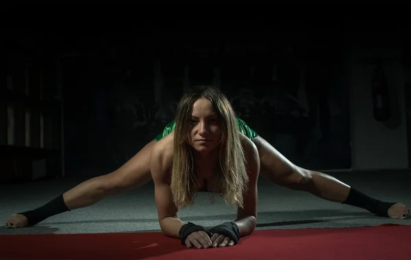Mujer kickboxer haciendo splits y embestidas —  Fotos de Stock