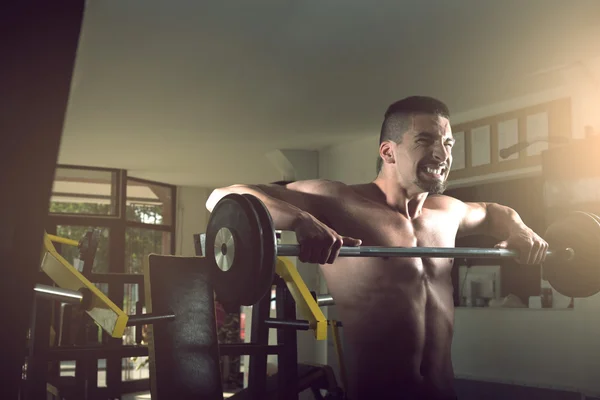 Jovem fazendo exercício de barbell no ginásio — Fotografia de Stock