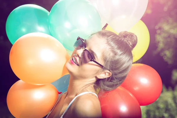 Meisje poseren met ballonnen in de natuur — Stockfoto