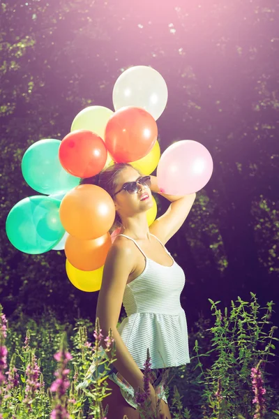 Menina posando com balões na natureza — Fotografia de Stock