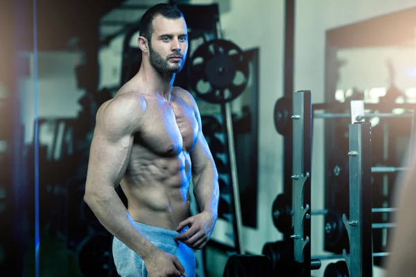 Hombre mostrando abdominales en el gimnasio —  Fotos de Stock