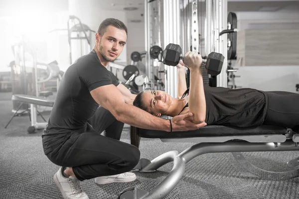 Mulher fazendo fitness com ajuda personal trainer . — Fotografia de Stock