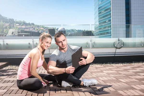 Entrenador personal sentado con su cliente — Foto de Stock