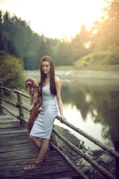 Vrouw met poedel hond bij bergmeer. — Stockfoto