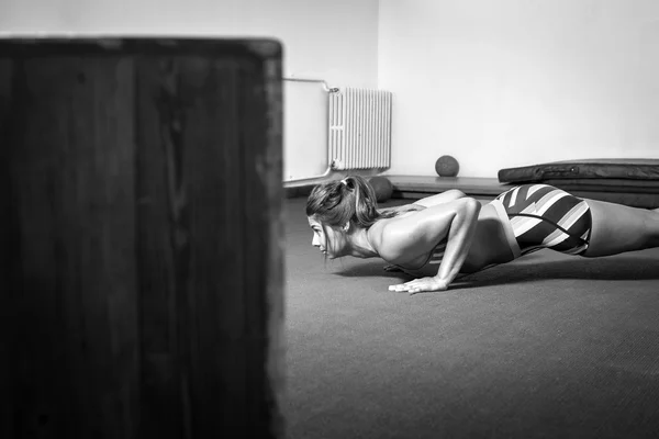 Menina fazendo flexões no ginásio — Fotografia de Stock