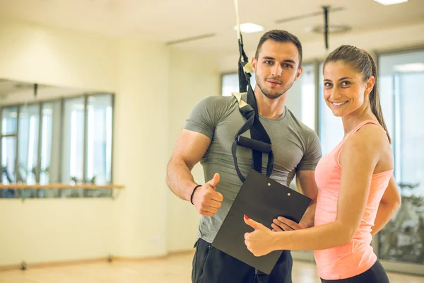 Personal Trainer mit Suspension zeigt dem Kunden Ergebnisse. — Stockfoto