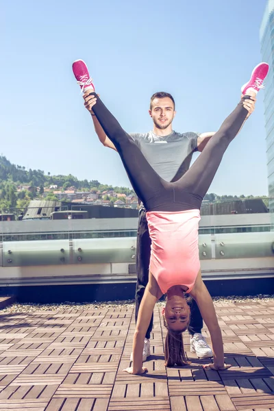 Handstand op dak met personal trainer. — Stockfoto