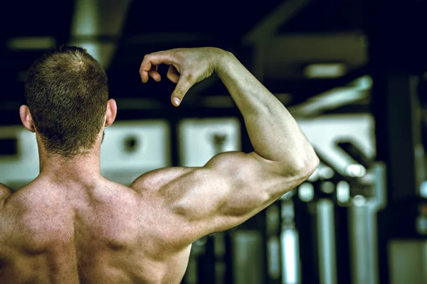 Homme montrant de retour dans la salle de gym — Photo