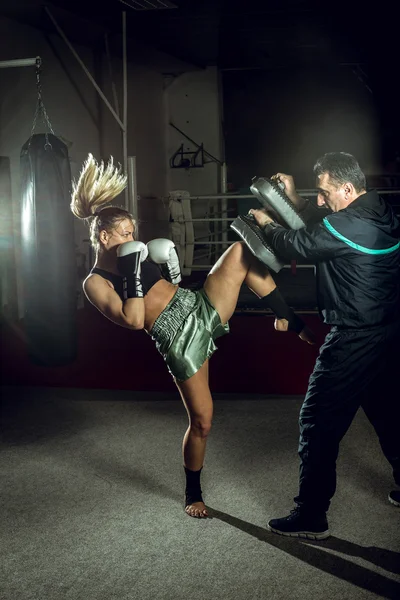 Boxing girl doing knee kick — Stock Photo, Image