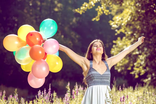 Chica con globos extendiendo los brazos —  Fotos de Stock