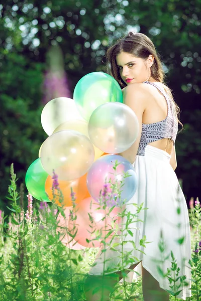 Chica posando con globos por detrás . — Foto de Stock