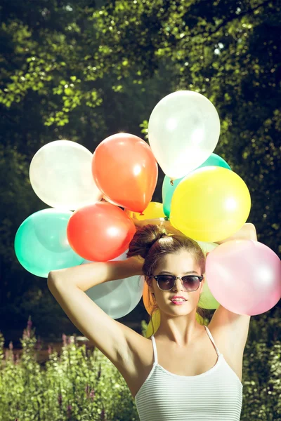 Meisje poseren met ballonnen in de natuur — Stockfoto