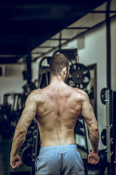 Homme montrant de retour dans la salle de gym — Photo