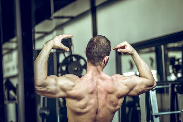 Man menunjukkan kembali di gym — Stok Foto