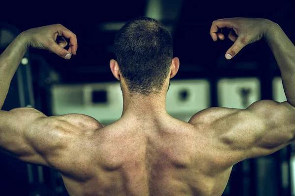 Man menunjukkan kembali di gym — Stok Foto