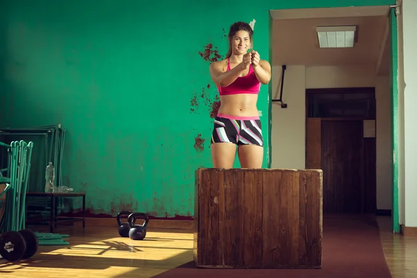 Девушка прыгает на коробке в спортзале — стоковое фото
