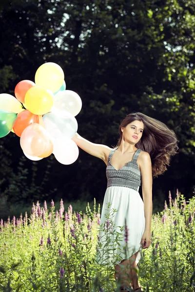 Flicka med ballonger i handen — Stockfoto