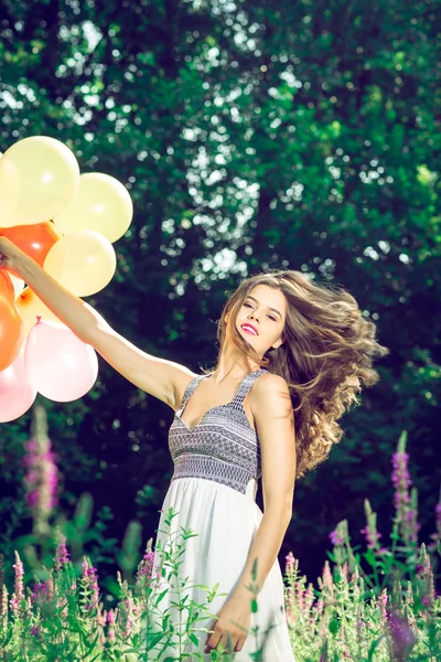 Chica sosteniendo globos en la mano —  Fotos de Stock