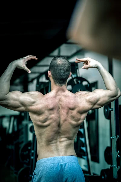 Hombre mostrando de nuevo en el gimnasio — Foto de Stock