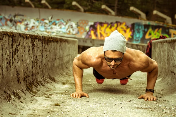 Slim fit man doing outdoor push ups — Stock Photo, Image