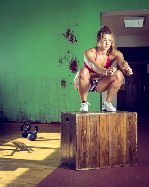 Flickan hoppar på box i gym — Stockfoto