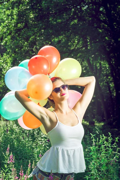 Menina posando com balões na natureza — Fotografia de Stock